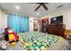 Comfortable bedroom with natural light, a ceiling fan, a colorful blanket, and a flat screen television at 717 E 137Th Ave, Tampa, FL 33613