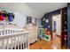 room featuring a crib, dresser with toys, and blue accent wall, complemented by hardwood flooring at 717 E 137Th Ave, Tampa, FL 33613
