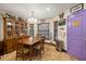 Cozy dining area featuring a wooden table and chairs, built-in cabinet, tile floor, and a door painted in a purple tone at 717 E 137Th Ave, Tampa, FL 33613