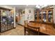 A dining area featuring a dark wood table, chairs, and a hutch, opening up to a kitchen with stainless steel refrigerator at 717 E 137Th Ave, Tampa, FL 33613