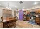 Well-lit kitchen and dining area, with stainless steel appliances, a table, a door in purple tone, and tile floor at 717 E 137Th Ave, Tampa, FL 33613