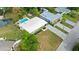 Stunning aerial view of a home with a sparkling pool, lush landscaping, and a spacious driveway leading to the garage at 7304 Lakeside Blvd, Tampa, FL 33614