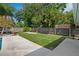 Landscaped backyard featuring green grass, a concrete pad and a well-kept wooden fence at 7304 Lakeside Blvd, Tampa, FL 33614