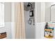 Clean white bathroom featuring a shower with black hardware, plus storage rack at 7304 Lakeside Blvd, Tampa, FL 33614