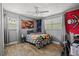 Bedroom with a ceiling fan, wood floors, a bed and creative wall decor at 7304 Lakeside Blvd, Tampa, FL 33614