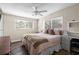 Cozy bedroom features a ceiling fan, wood floors, and natural light from two windows at 7304 Lakeside Blvd, Tampa, FL 33614