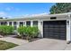 A beautiful close-up shot of a single-story home with dark garage door, black fixtures and bright white trim at 7304 Lakeside Blvd, Tampa, FL 33614