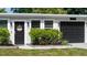 Charming single-story home with well-maintained landscaping, featuring a welcoming entrance and a dark garage door at 7304 Lakeside Blvd, Tampa, FL 33614