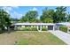 Charming single-story home with well-manicured landscaping, featuring a welcoming entrance and a dark garage door at 7304 Lakeside Blvd, Tampa, FL 33614
