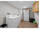 Practical laundry room with washer, dryer, refrigerator, and wood-look flooring at 7304 Lakeside Blvd, Tampa, FL 33614