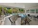 Cozy covered patio with comfortable seating overlooks a sparkling pool and lush tropical landscaping at 7304 Lakeside Blvd, Tampa, FL 33614