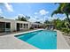 Backyard view of the pool surrounded by lounge furniture and tropical foliage at 7304 Lakeside Blvd, Tampa, FL 33614