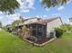 Rear exterior view of a home featuring a sunroom addition and lush backyard with tasteful landscaping at 7360 Ulmerton Rd # 18A, Largo, FL 33771