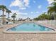 Community pool surrounded by palm trees and lounge chairs at 7360 Ulmerton Rd # 18A, Largo, FL 33771