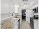 Modern kitchen with white cabinets, granite countertops, stainless steel appliances, and a bright, airy atmosphere at 7360 Ulmerton Rd # 18A, Largo, FL 33771