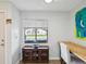 Bright office space with a view of the front yard, featuring a wooden desk, cabinet, and comfortable seating at 7360 Ulmerton Rd # 18A, Largo, FL 33771