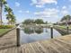 Community pond with dock featuring manicured landscaping, palm trees, and tranquil water at 7360 Ulmerton Rd # 18A, Largo, FL 33771