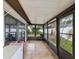 Large sunroom with tiled flooring, multiple access points, and views of the landscaped backyard at 7360 Ulmerton Rd # 18A, Largo, FL 33771