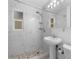 Bright bathroom with modern fixtures, tiled shower, and a pedestal sink at 8020 24Th Ave N, St Petersburg, FL 33710