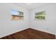 Cozy bedroom with wood-look flooring and bright, natural light from two windows at 8020 24Th Ave N, St Petersburg, FL 33710