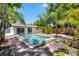 Sparkling swimming pool surrounded by brick pavers, tropical plants, and a fenced yard at 8020 24Th Ave N, St Petersburg, FL 33710