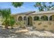 Charming single-story home featuring an arched entryway, stone accents, and tropical landscaping at 8020 28Th N Ave, St Petersburg, FL 33710