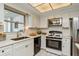 Bright kitchen with white cabinets, stainless steel appliances, and tile backsplash at 8020 28Th N Ave, St Petersburg, FL 33710