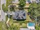 Aerial view of a house with a pool and solar panels on the roof surrounded by green landscaping and trees at 8095 35Th Ave N, St Petersburg, FL 33710