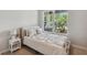 Cozy bedroom featuring a comfortable bed, side table, and a large window with a garden view at 8095 35Th Ave N, St Petersburg, FL 33710