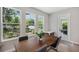 Bright dining room featuring a modern wood table and a wall of windows overlooking the lush backyard at 8095 35Th Ave N, St Petersburg, FL 33710