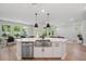 Open-concept kitchen with stainless steel appliances and center island, leading to dining and living areas at 8095 35Th Ave N, St Petersburg, FL 33710