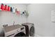 Functional laundry room with modern gray washer and dryer with wire rack shelving at 8095 35Th Ave N, St Petersburg, FL 33710