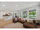 Open concept living room with access to the kitchen, wood floors, and large windows at 8095 35Th Ave N, St Petersburg, FL 33710
