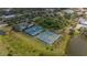 An aerial shot showcasing community tennis courts and green spaces by a serene lake at 8223 Haven Harbour Way, Bradenton, FL 34212