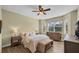 Comfortable bedroom featuring neutral tones, a ceiling fan, and a window overlooking a screened patio at 8223 Haven Harbour Way, Bradenton, FL 34212