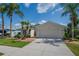 Charming home with a well-manicured lawn, tropical landscaping, and a paved driveway leading to a two-car garage at 8223 Haven Harbour Way, Bradenton, FL 34212