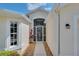 Welcoming front entrance with a decorative screen door, fresh flowers, and manicured landscaping at 8223 Haven Harbour Way, Bradenton, FL 34212