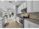 Well-lit kitchen featuring stainless steel appliances, white cabinetry, and a stylish backsplash at 8223 Haven Harbour Way, Bradenton, FL 34212