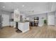 Open-concept kitchen featuring stainless appliances, white cabinetry, a large center island, and sight lines to the living room at 8223 Haven Harbour Way, Bradenton, FL 34212