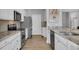 Bright kitchen featuring stainless steel appliances, white cabinetry, granite countertops, and hardwood floors at 8223 Haven Harbour Way, Bradenton, FL 34212