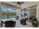 Enclosed patio with comfortable seating, a ceiling fan, and beautiful views of the pool and lush landscape at 8223 Haven Harbour Way, Bradenton, FL 34212