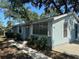 Quaint home with light blue siding and manicured bushes lining the front pathway at 8618 N Orangeview Ave, Tampa, FL 33617