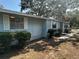 A cozy home featuring light blue siding, trimmed bushes, and a stone pathway at 8618 N Orangeview Ave, Tampa, FL 33617