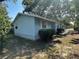 Exterior side view with light blue siding and green shrubs at 8618 N Orangeview Ave, Tampa, FL 33617