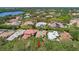 Aerial shot of a home nestled among lush trees and neighboring properties near a lake at 8708 Laurel N Dr, Pinellas Park, FL 33782