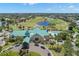 Aerial view of a community clubhouse with pool, golf course and lush landscaping, perfect for recreation at 8708 Laurel N Dr, Pinellas Park, FL 33782
