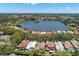 An aerial view showcasing homes nestled along a picturesque lake, surrounded by lush greenery at 8708 Laurel N Dr, Pinellas Park, FL 33782