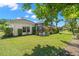 Lush backyard featuring a screen-enclosed pool, verdant lawn, and mature landscaping at 8708 Laurel N Dr, Pinellas Park, FL 33782