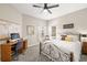 Well-lit bedroom with desk, ceiling fan, and neutral color palette at 8708 Laurel N Dr, Pinellas Park, FL 33782