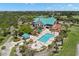 Aerial view of a beautiful clubhouse, sparkling swimming pool, and manicured landscaping at 8708 Laurel N Dr, Pinellas Park, FL 33782